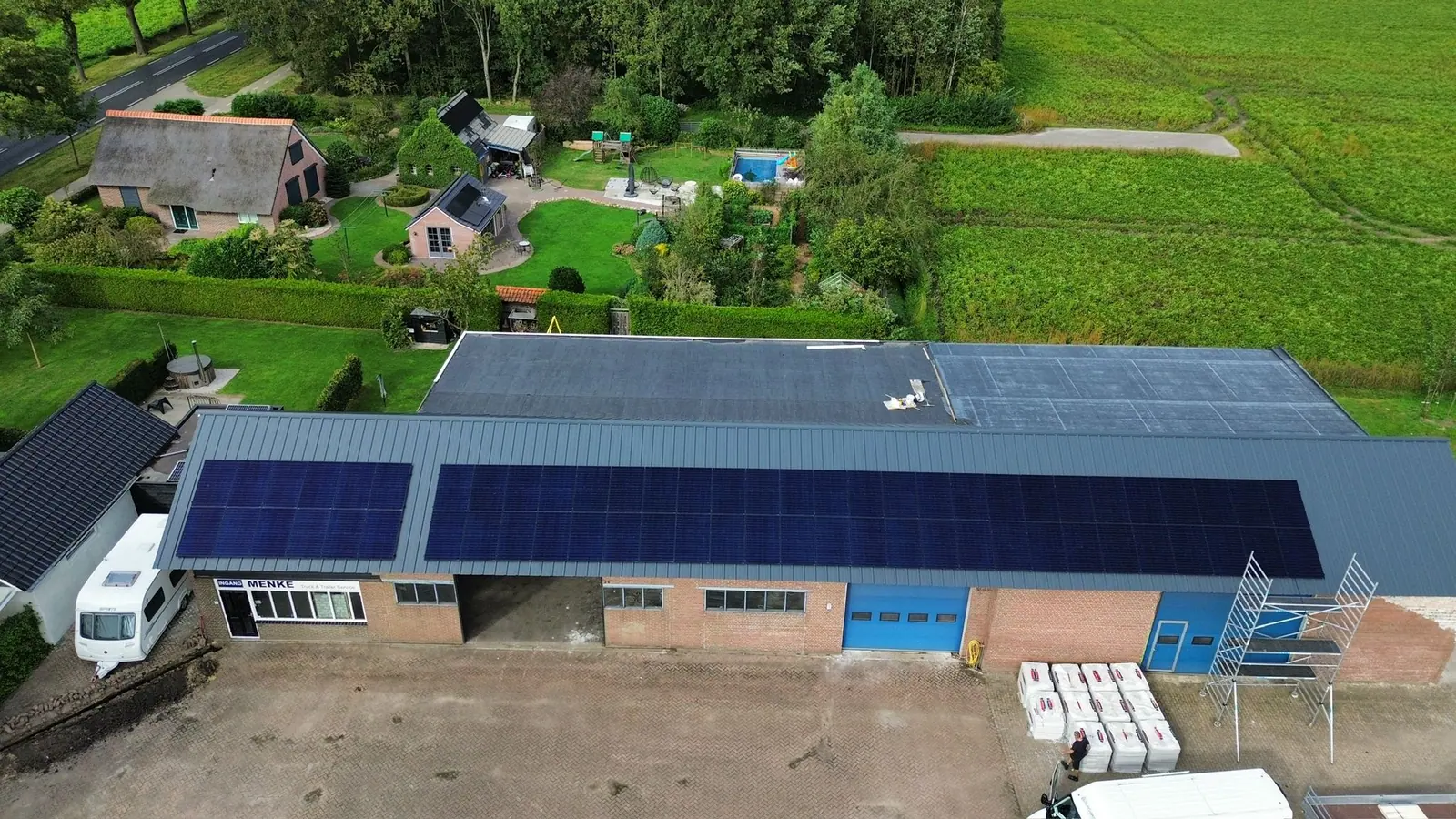 Zonnepanelen op het dak van een bedrijfshal, gezien vanuit de lucht
