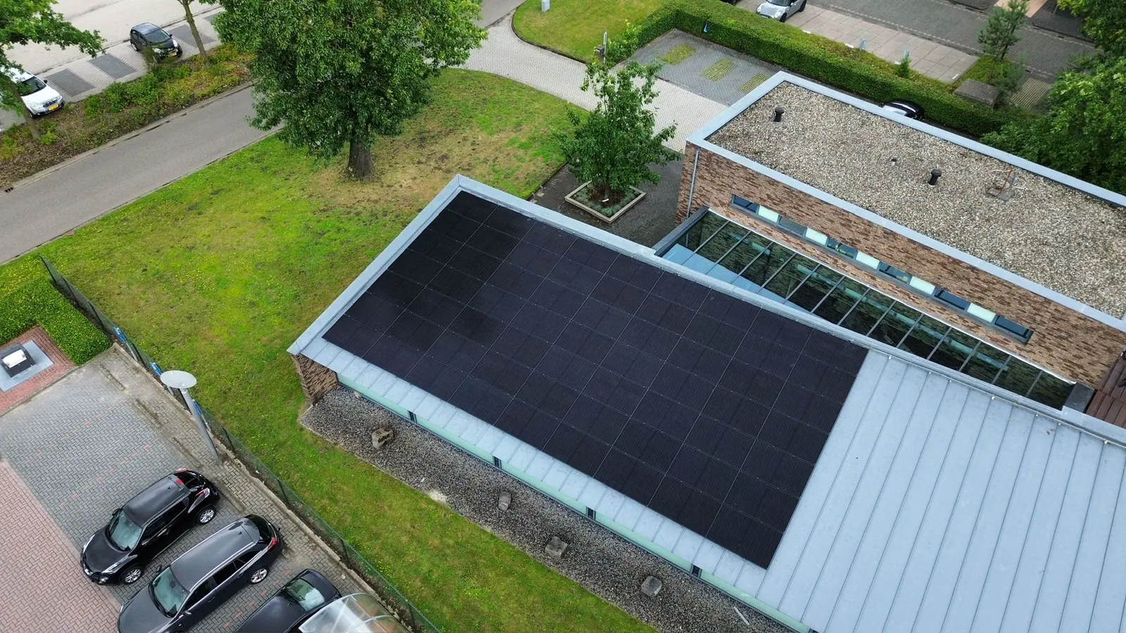 Zonnepanelen op een plat dak van een bedrijfspand, gezien vanuit de lucht